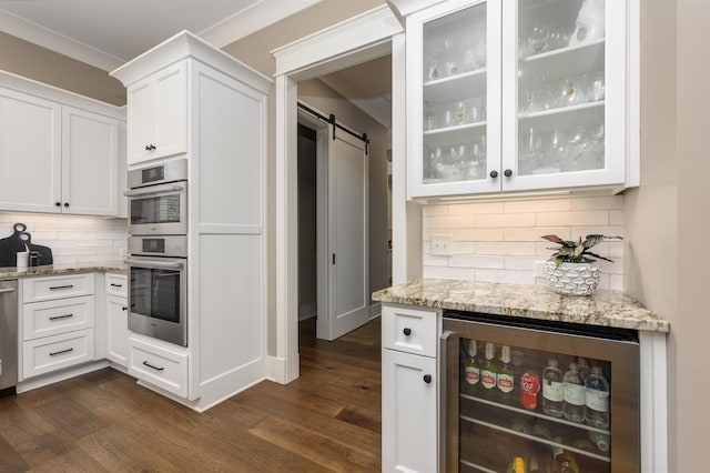 kitchen with beverage cooler, a barn door, dark wood-style floors, and light stone countertops