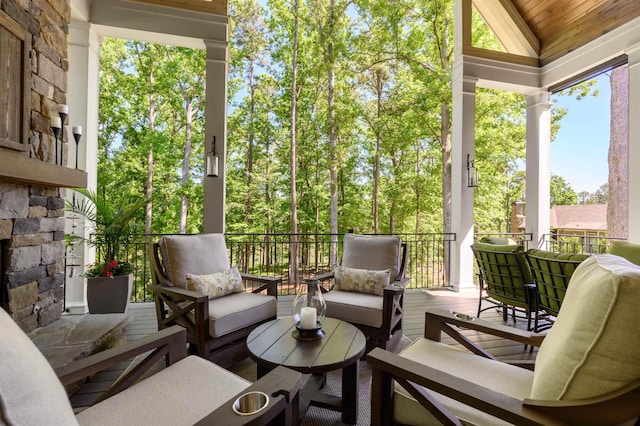 sunroom / solarium featuring an outdoor living space with a fireplace and lofted ceiling