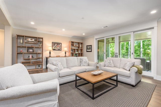 living room with wood finished floors, recessed lighting, and ornamental molding