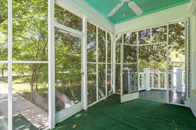 unfurnished sunroom featuring ceiling fan