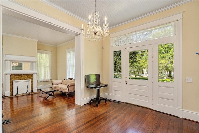 foyer entrance with crown molding, a wealth of natural light, dark hardwood / wood-style floors, and a chandelier