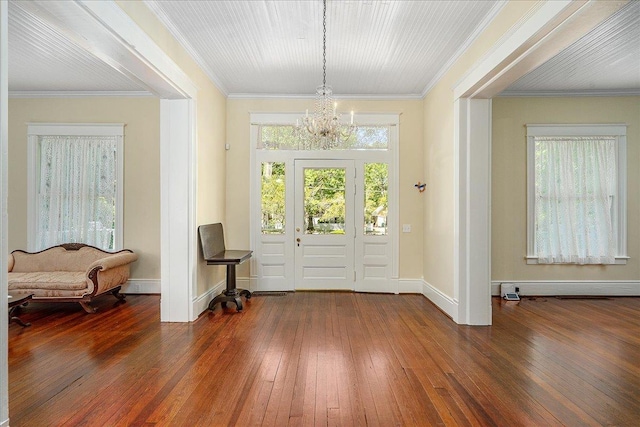 entryway with an inviting chandelier, ornamental molding, and dark hardwood / wood-style floors