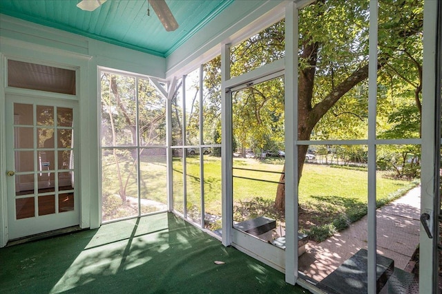 unfurnished sunroom featuring ceiling fan