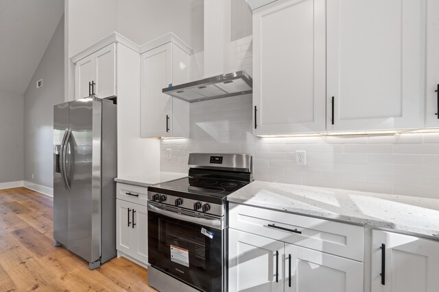 103 Spruce Ln, Eatonton, GA 31024 - kitchen featuring stainless steel appliances, wall chimney exhaust hood, light wood finished floors, white cabinets, and lofted ceiling