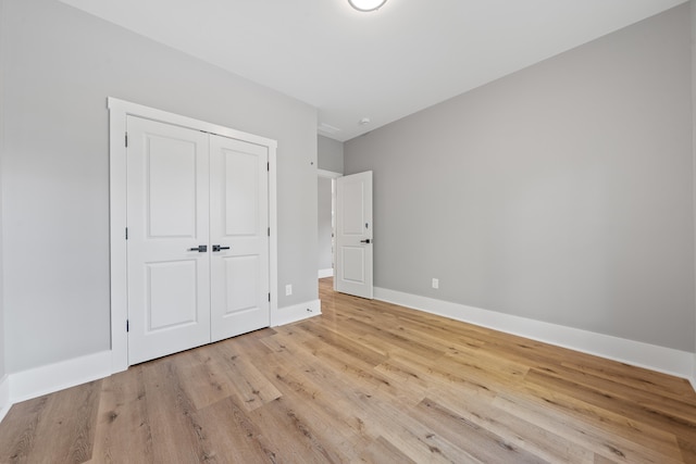 103 Spruce Ln, Eatonton, GA 31024 - unfurnished bedroom with light wood-style floors, baseboards, and a closet