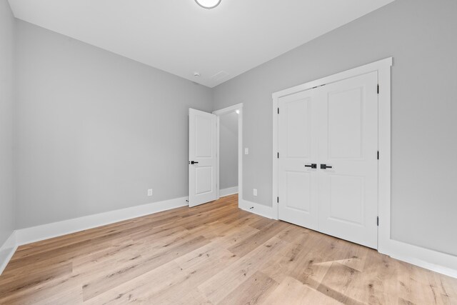 103 Spruce Ln, Eatonton, GA 31024 - unfurnished bedroom featuring baseboards, light wood-style floors, and a closet