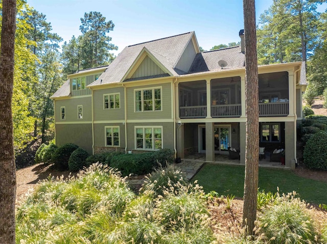 rear view of house with a lawn and a sunroom