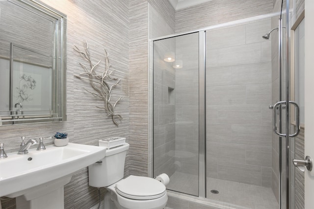 bathroom with walk in shower, toilet, sink, tile walls, and backsplash