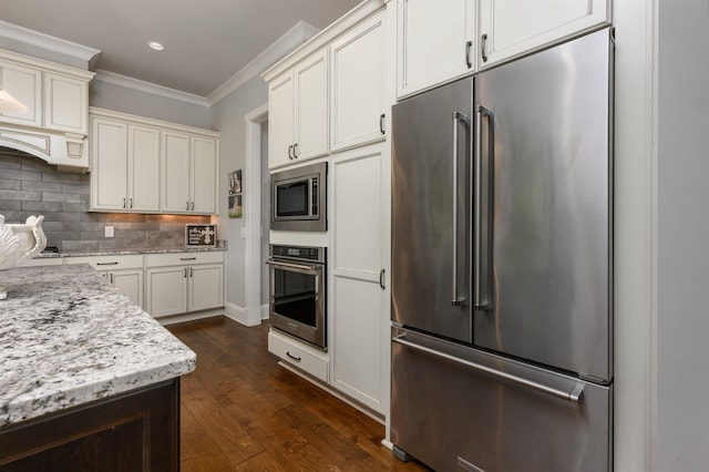 kitchen featuring dark wood-type flooring, light stone counters, crown molding, stainless steel appliances, and decorative backsplash