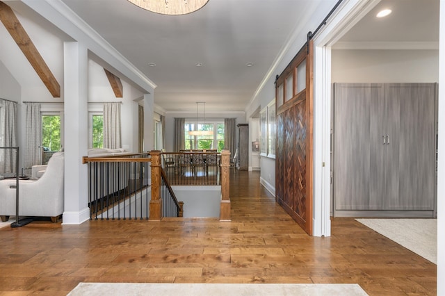 hall featuring hardwood / wood-style flooring, crown molding, a barn door, and beamed ceiling