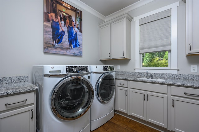 laundry area with washing machine and clothes dryer, sink, cabinets, ornamental molding, and dark hardwood / wood-style floors