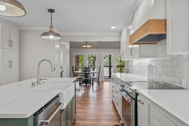291 Power Point Rd, Milledgeville, GA 31061 - kitchen with stainless steel appliances, custom exhaust hood, white cabinetry, light wood finished floors, and crown molding