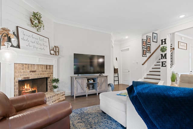 living room with dark wood-type flooring, ornamental molding, and a brick fireplace