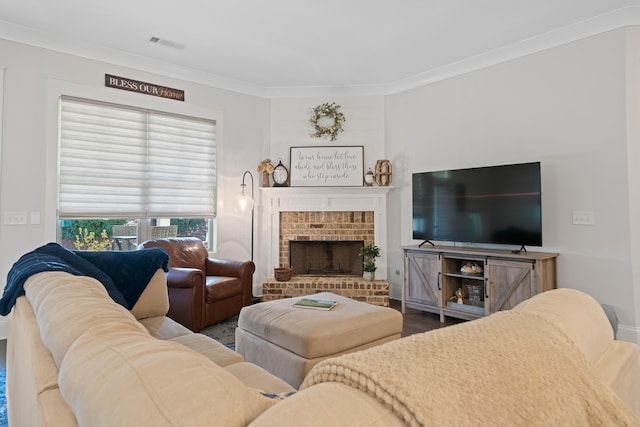 living room with hardwood / wood-style flooring, ornamental molding, and a fireplace