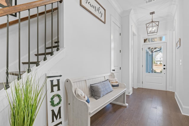 entrance foyer featuring dark hardwood / wood-style flooring, ornamental molding, and an inviting chandelier