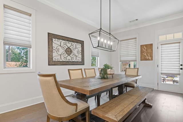 dining space with crown molding, a chandelier, and dark hardwood / wood-style flooring