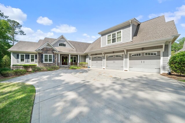 1101 Shoal Creek Ct, Greensboro, GA 30642 - craftsman house featuring an attached garage, roof with shingles, stone siding, and concrete driveway