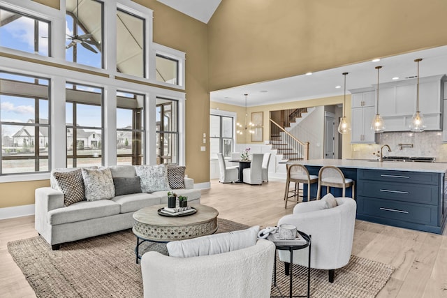 1201 Askew Trl, Greensboro, GA 30642 - living area featuring a notable chandelier, stairs, baseboards, light wood-type flooring, and a towering ceiling