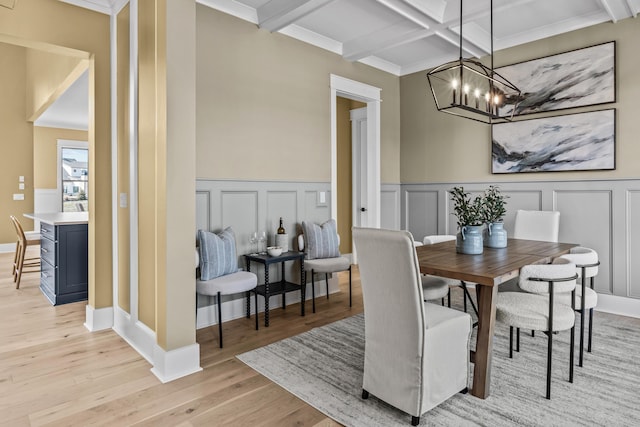 1201 Askew Trl, Greensboro, GA 30642 - dining area featuring light wood-style floors, an inviting chandelier, beam ceiling, and a decorative wall