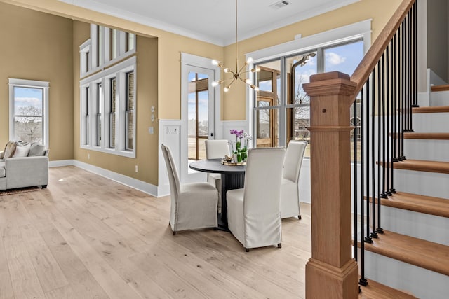 1201 Askew Trl, Greensboro, GA 30642 - dining area with crown molding, stairs, wood finished floors, and a notable chandelier