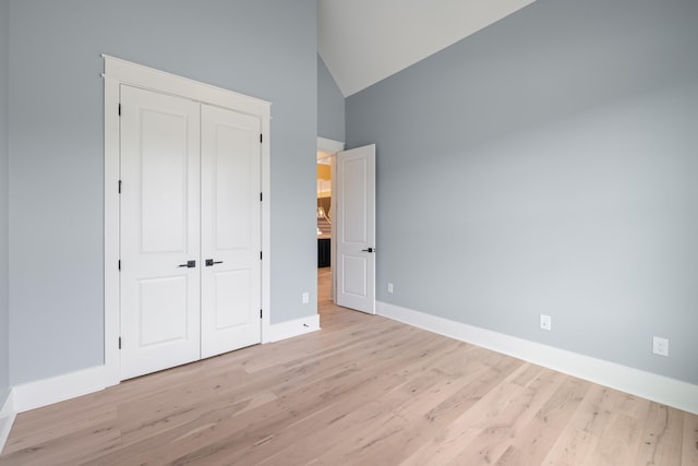 1201 Askew Trl, Greensboro, GA 30642 - unfurnished bedroom with light wood-type flooring, baseboards, high vaulted ceiling, and a closet