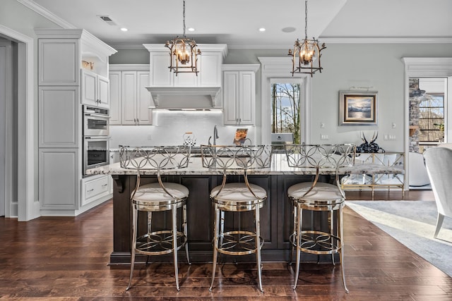 kitchen featuring white cabinetry, decorative light fixtures, light stone countertops, and a chandelier