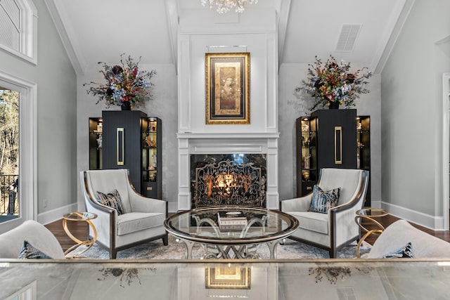 living area featuring crown molding, a high end fireplace, and wood-type flooring