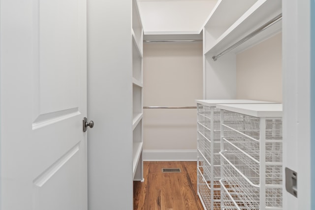 spacious closet with dark wood-type flooring