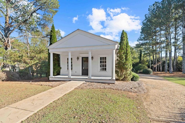 neoclassical / greek revival house featuring covered porch and a front lawn