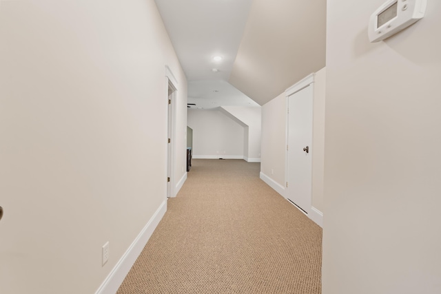 corridor with lofted ceiling and light carpet