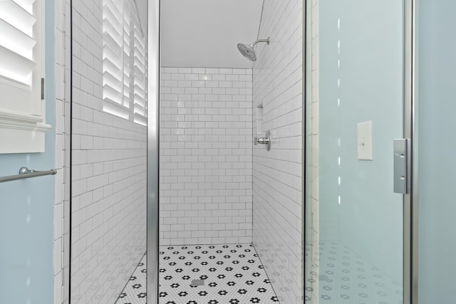 bathroom with a shower with door