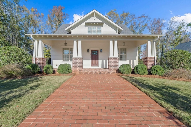 view of front facade featuring covered porch and a front lawn