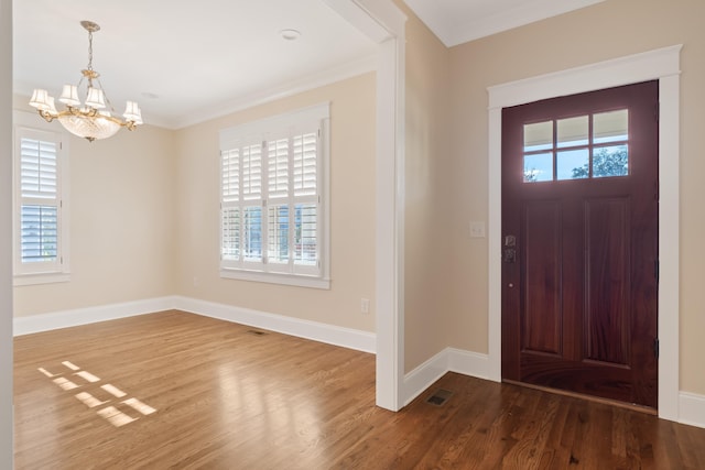 entryway featuring hardwood / wood-style floors, a notable chandelier, and ornamental molding