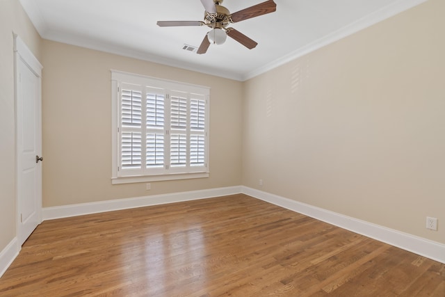 spare room featuring ceiling fan, wood-type flooring, and ornamental molding