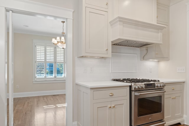 kitchen with white cabinets, decorative backsplash, custom range hood, stainless steel gas range, and light wood-type flooring