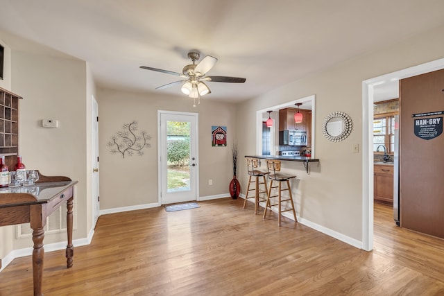 entrance foyer with ceiling fan, sink, and light hardwood / wood-style floors