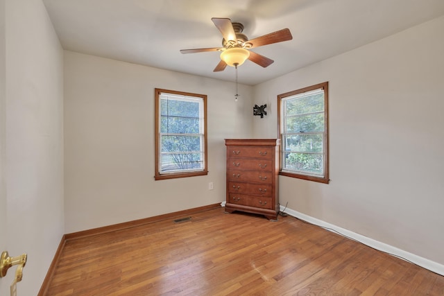 unfurnished room with plenty of natural light, ceiling fan, and light wood-type flooring