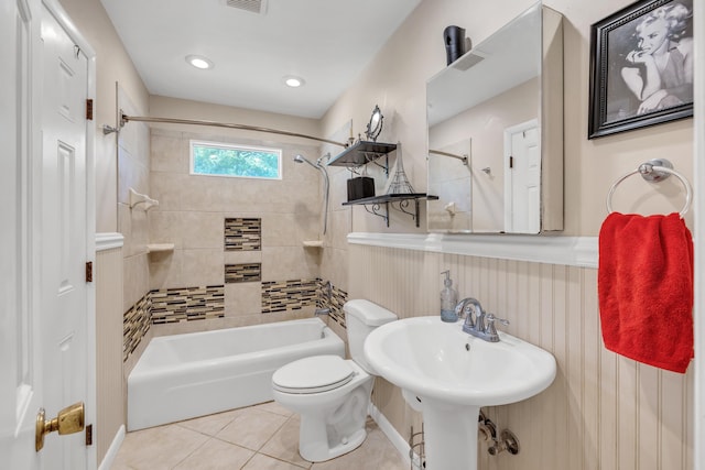 bathroom featuring tile patterned flooring, tiled shower / bath, and toilet