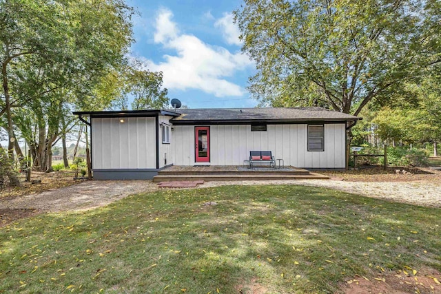 rear view of property featuring a lawn