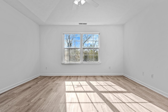 empty room featuring visible vents, baseboards, and wood finished floors