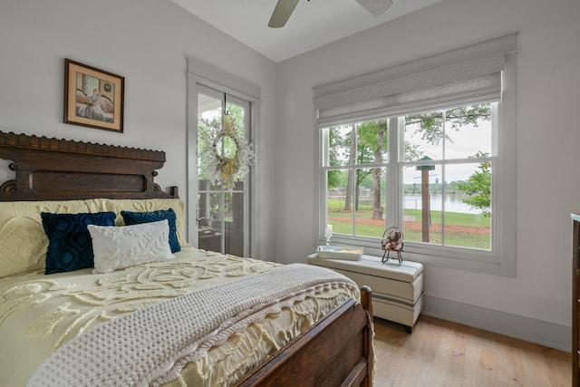 113 Daisy Trl, Milledgeville, GA 31061 - bedroom featuring baseboards, light wood-style floors, a ceiling fan, and a water view