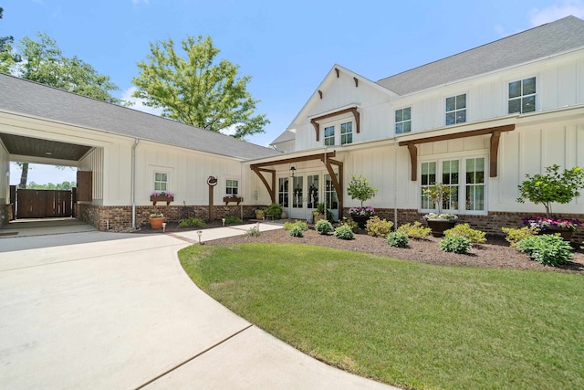 113 Daisy Trl, Milledgeville, GA 31061 - modern farmhouse featuring board and batten siding, roof with shingles, a front lawn, french doors, and brick siding