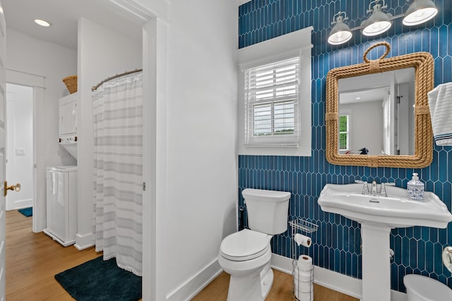 113 Daisy Trl, Milledgeville, GA 31061 - bathroom featuring tile walls, stacked washer and clothes dryer, toilet, and wood finished floors