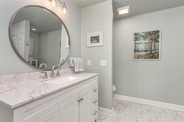 bathroom with baseboards, toilet, vanity, and tile patterned flooring