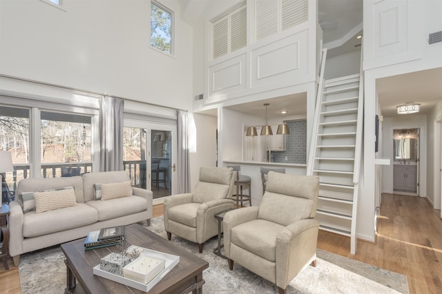 living room featuring visible vents, a high ceiling, and light wood finished floors