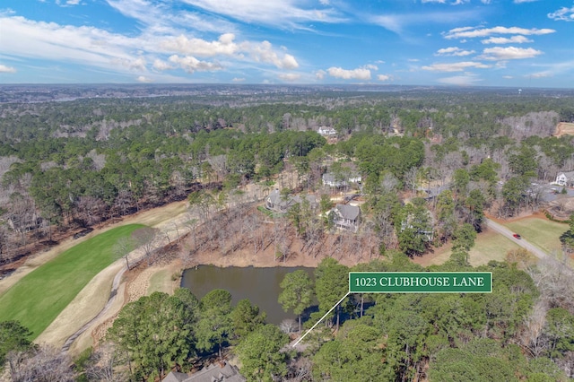 birds eye view of property with a wooded view and a water view