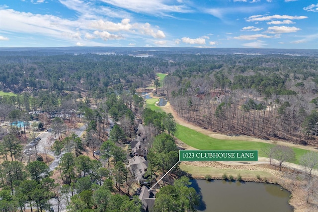 bird's eye view featuring a wooded view and a water view