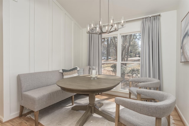 sitting room with a notable chandelier, baseboards, and light wood-style floors