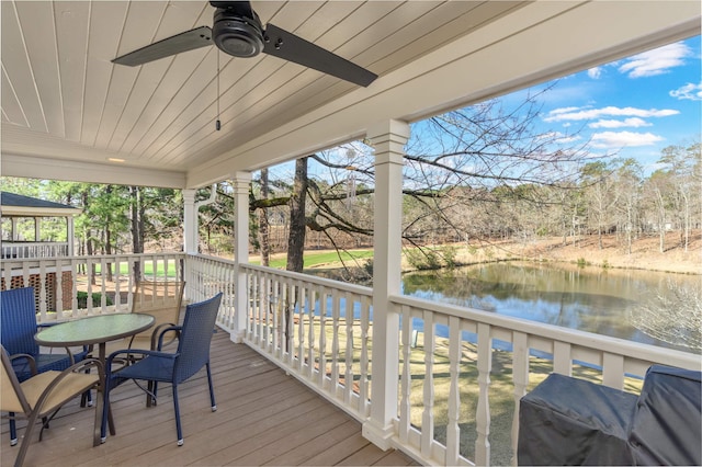 wooden deck with a grill, ceiling fan, and a water view