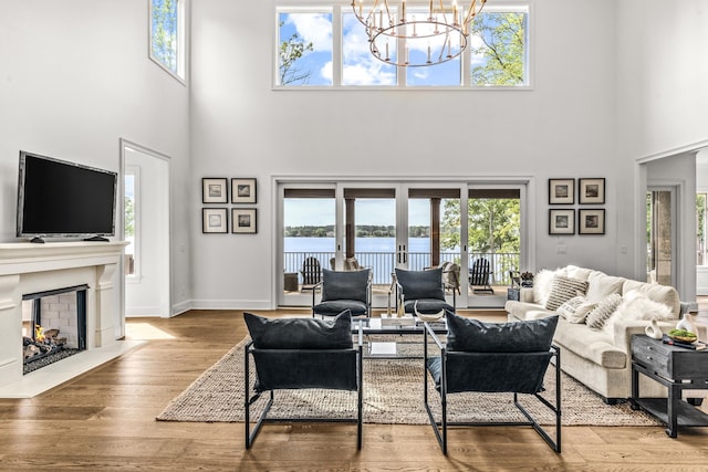 living area with a wealth of natural light, a chandelier, and a high ceiling